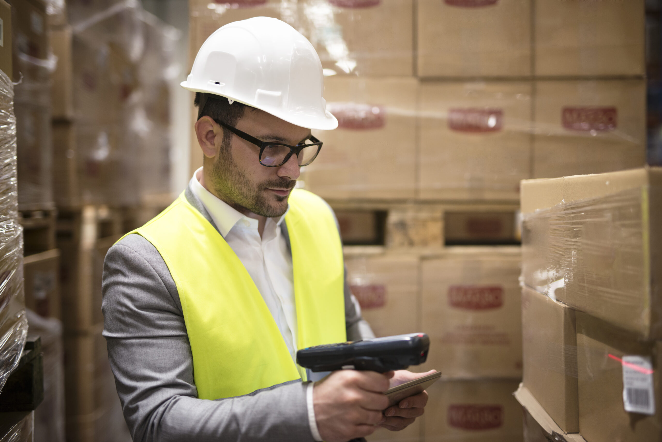 Warehouse worker checking parcels with bar code reader.